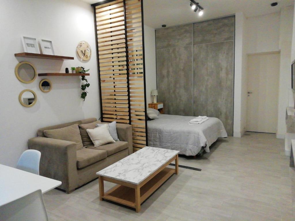 Sala de estar con cama, sofá y mesa en Departamento céntrico en Planta baja en San Miguel de Tucumán