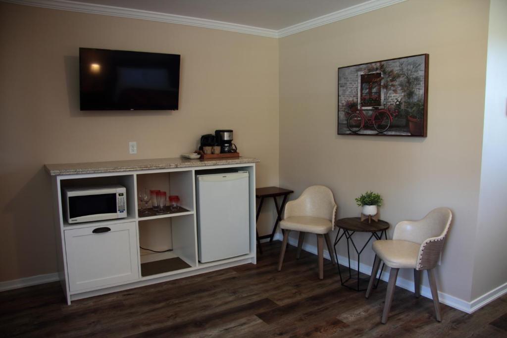a living room with a tv and a table and chairs at CARLETON INN & COTTAGES in Bridgetown