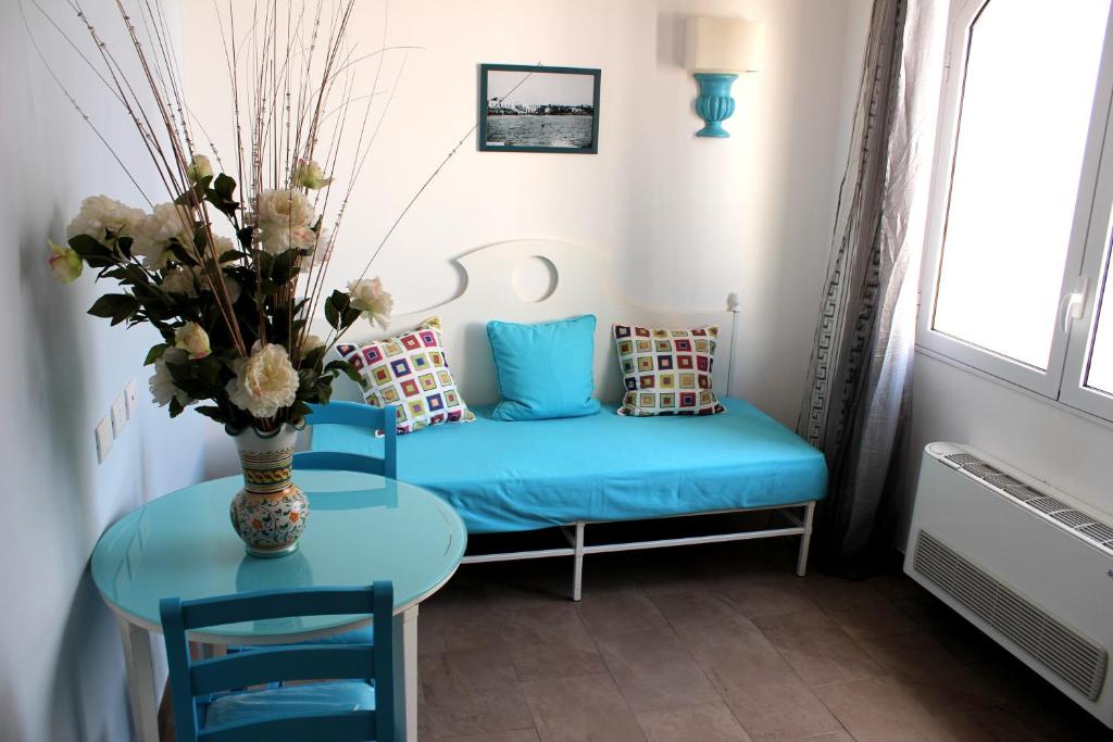 a living room with a blue couch and a table at Hotel O'scià in Lampedusa