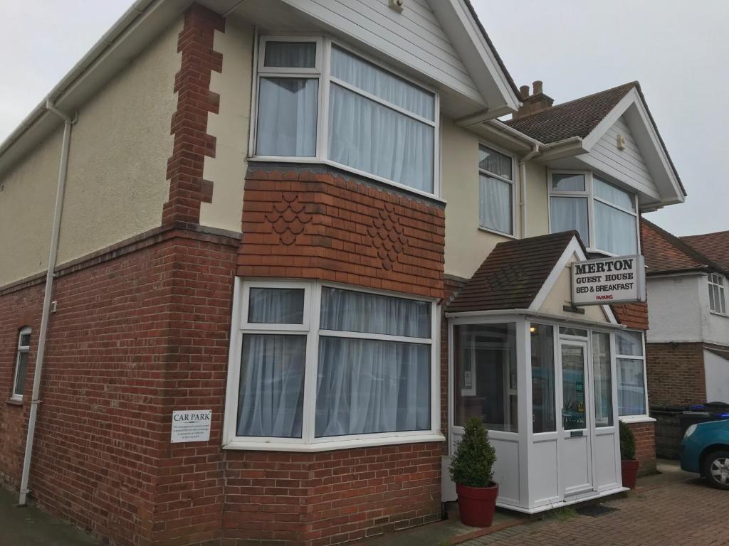a red brick house with a sign in front of it at Merton House in Worthing