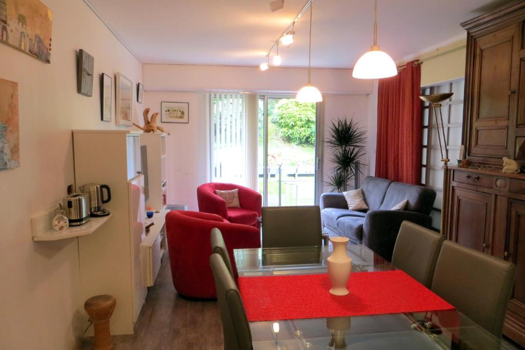 ein Wohnzimmer mit einem roten Tisch und Stühlen in der Unterkunft Mes Oasis Nancy in Villers-lès-Nancy