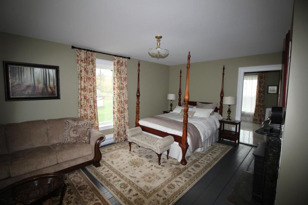 um quarto com uma cama e um sofá em Maplehurst Manor Bed and Breakfast em Dorchester