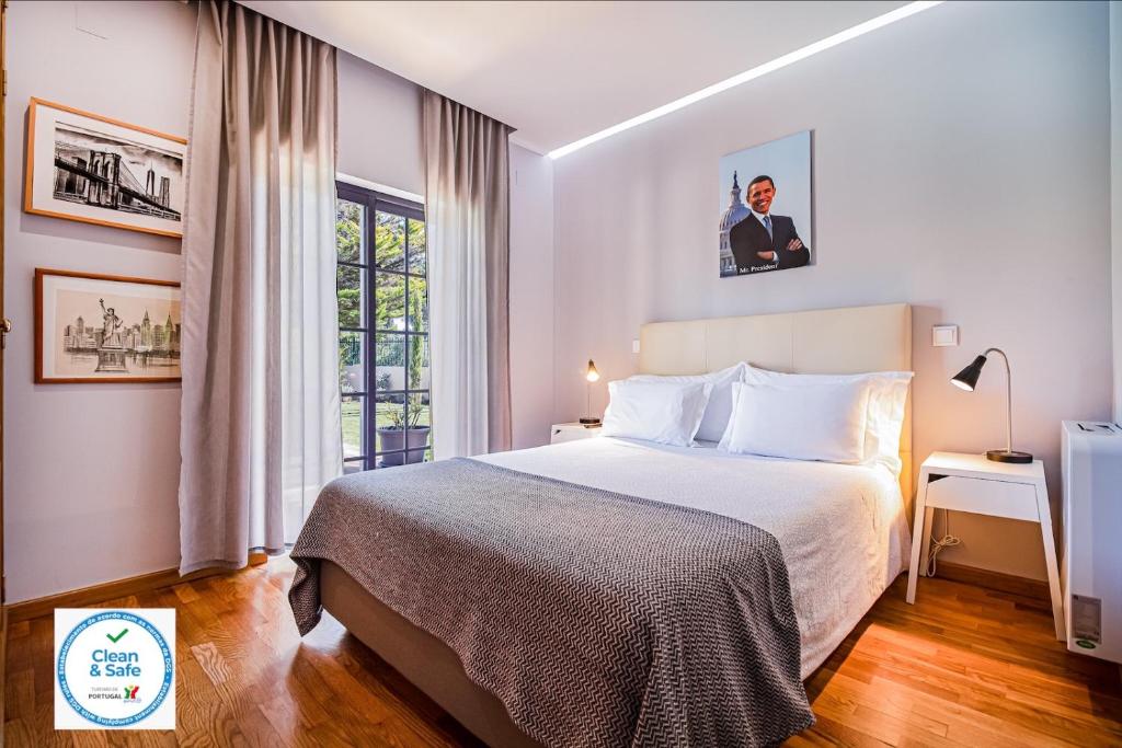 a hotel room with a bed and a window at Buganvilias Do Meco Guest house in Sesimbra