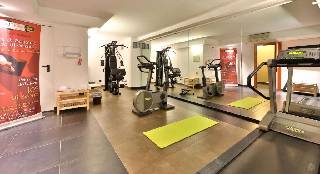 a gym with treadmills and ellipticals in a room at Hotel Cappello D'Oro, BW Signature Collection in Bergamo