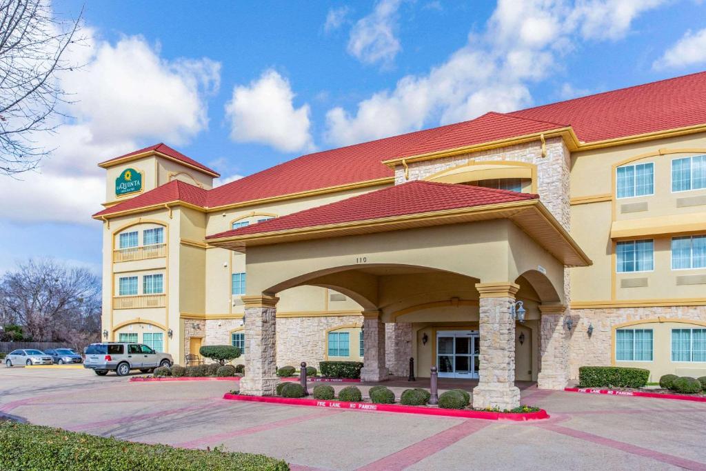 a large yellow building with a clock tower at La Quinta by Wyndham Ennis in Ennis