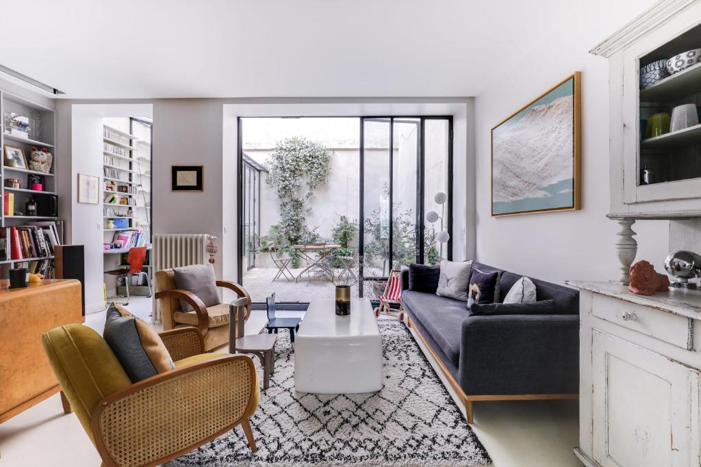 een woonkamer met een bank en een tafel bij Sumptuous house with patio in Parijs