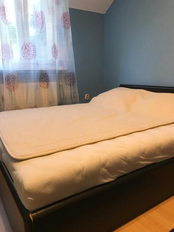 a bed sitting in a room with a window at DOM OTWARTY DLA GOŚCI in Gdynia