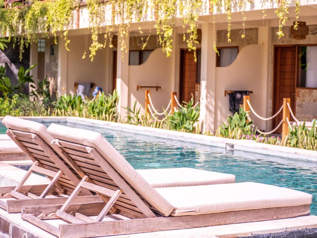 2 sedie a sdraio accanto alla piscina di Mango Lodge a Selong Belanak