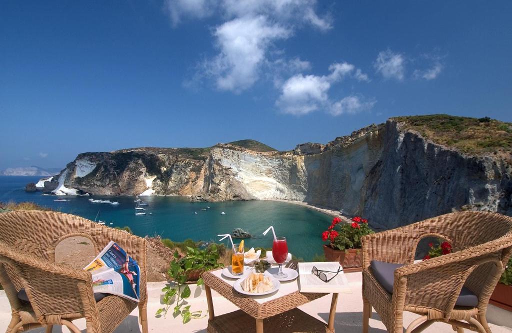 a table and chairs with a view of the ocean at Hotel Chiaia Di Luna in Ponza
