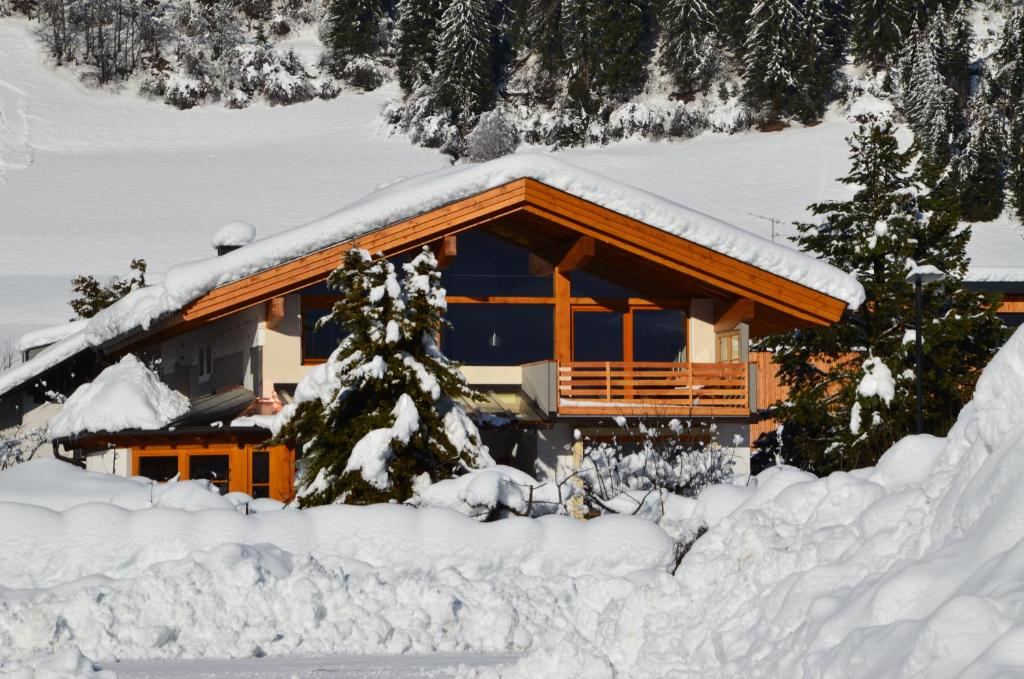 ein mit Schnee bedecktes Blockhaus in der Unterkunft Ferienwohnung Sir in Sillian