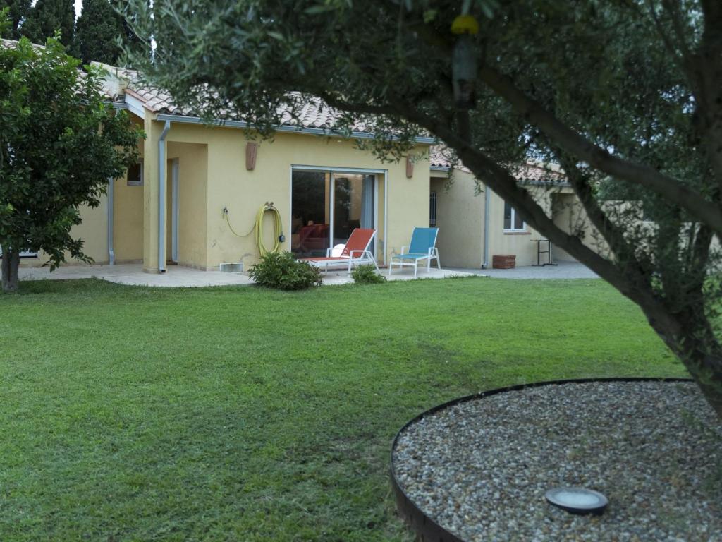 Millas的住宿－La Casa Nert，院子内带两把椅子的房子