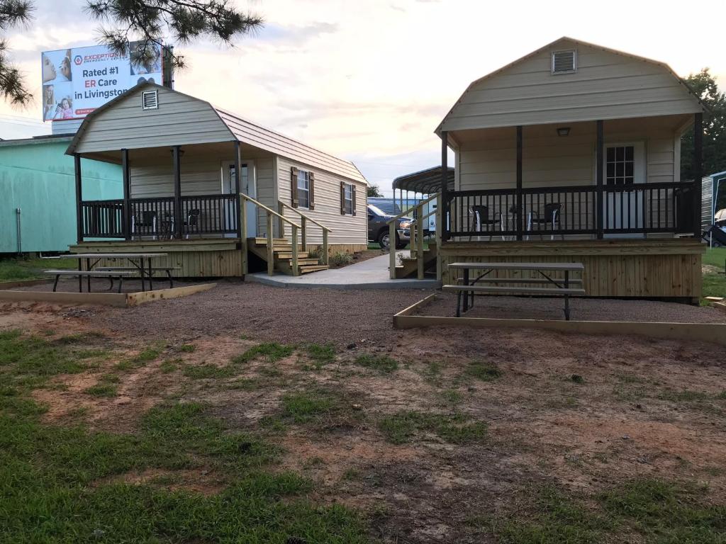 two small buildings with benches in a yard at Kickapoo Shores Waterfront Cottages in Onalaska