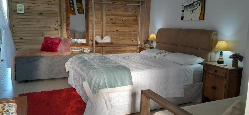 アララングアにあるEstúdio conceito aberto - 3 pessoasの木製の壁のベッドルーム1室(ベッド1台付)
