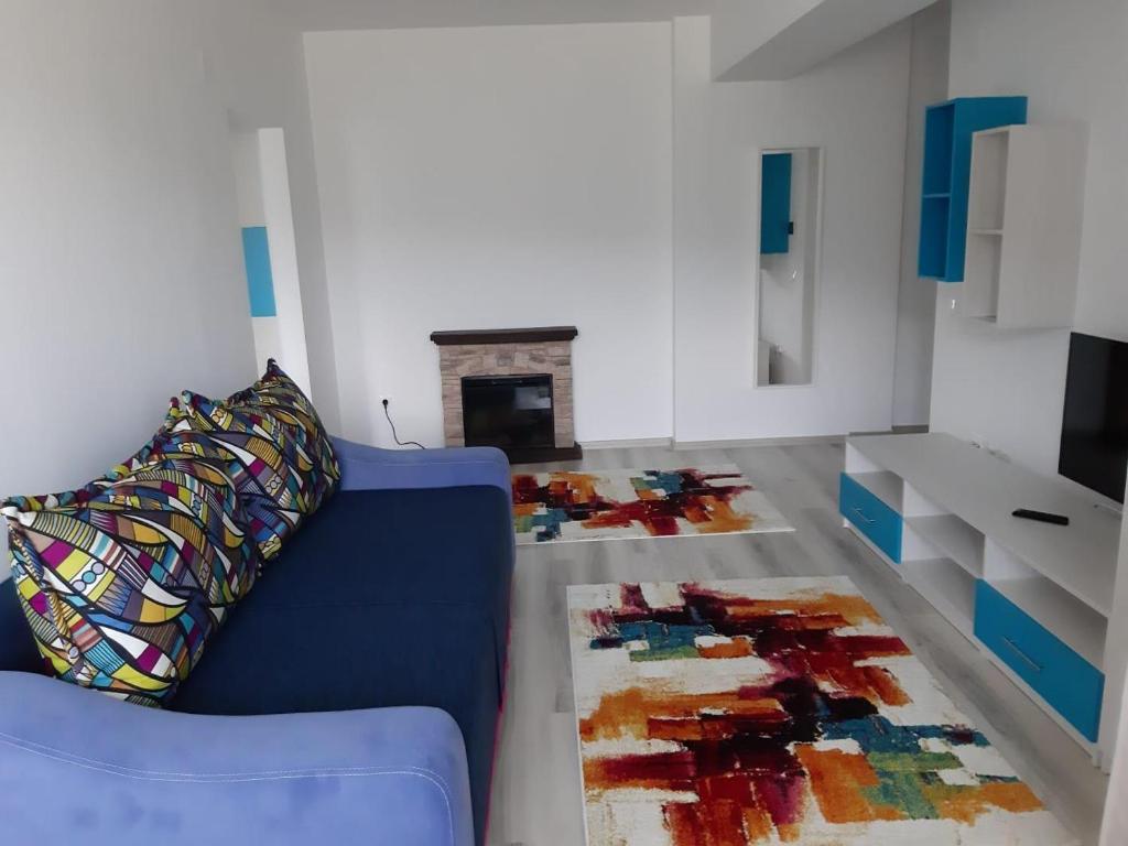 een woonkamer met een blauwe bank en een open haard bij DORIN COLINA MAREI in Sinaia