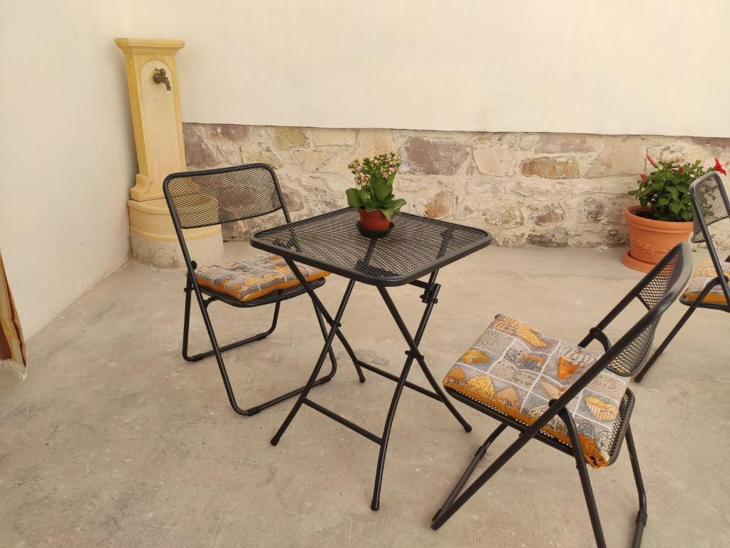 ein Tisch und zwei Stühle und ein Tisch mit einer Pflanze darauf in der Unterkunft B&B 24 Maggio in Carloforte
