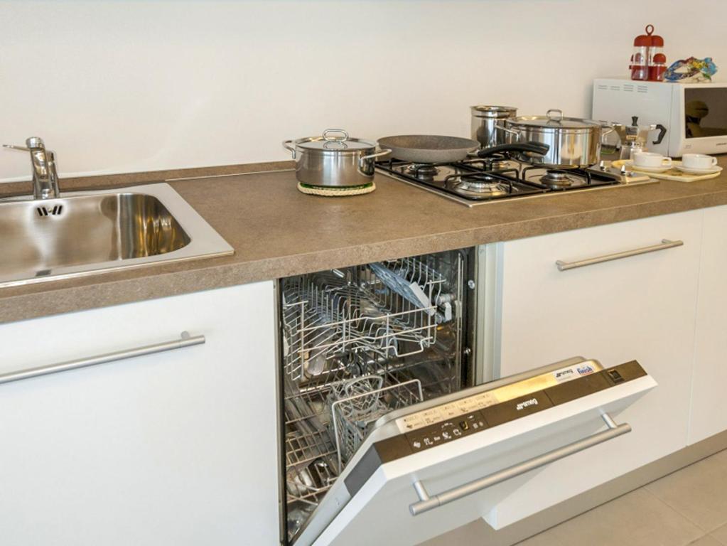 an open dishwasher in a kitchen next to a sink at Portofelice Camping Village in Eraclea Mare