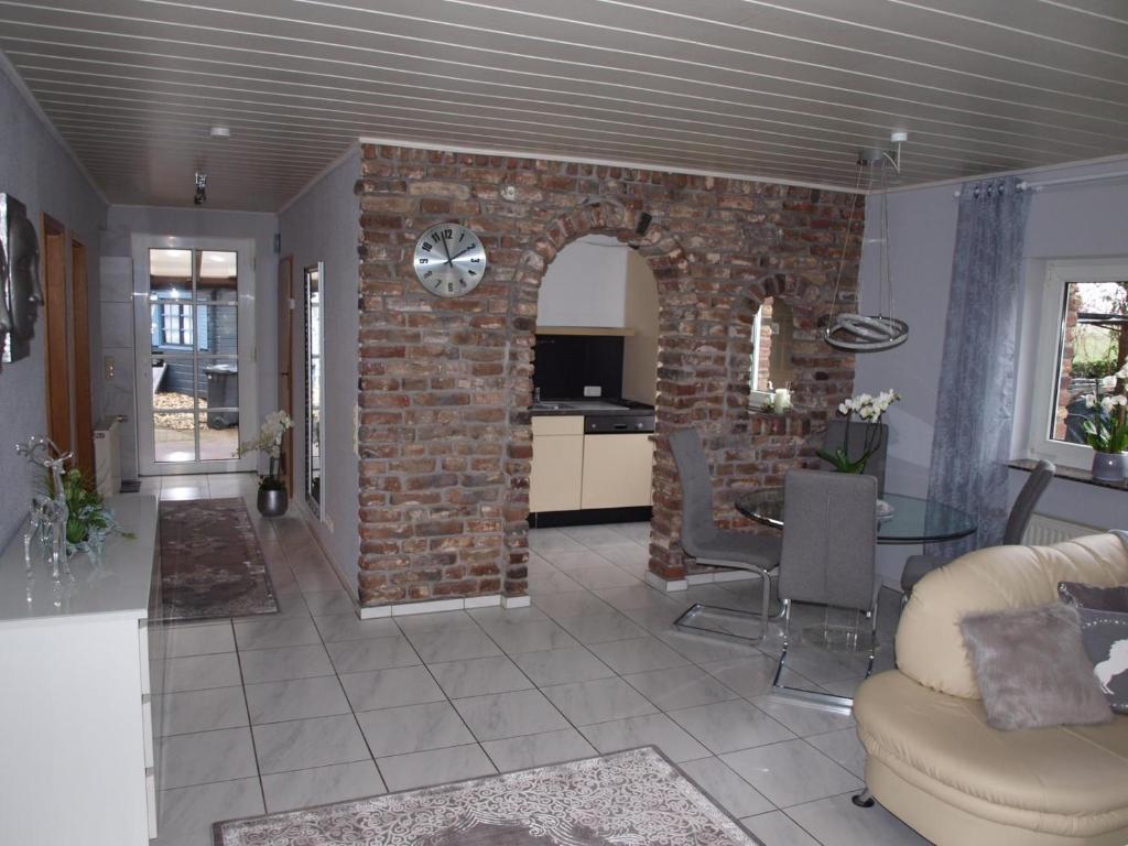 a living room with a brick wall with a clock at Ferienwohnung Pasch-Wittke in Geldern