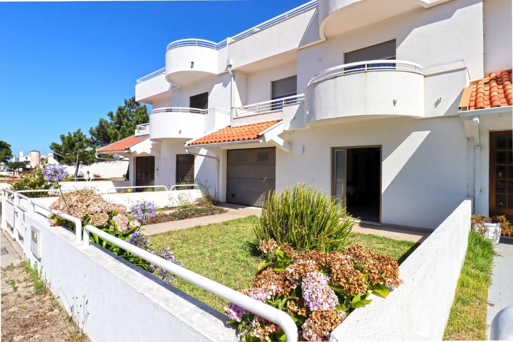 a white house with flowers in front of it at Casa da Bene - House Near the Amorosa Beach with Seaview in Viana do Castelo