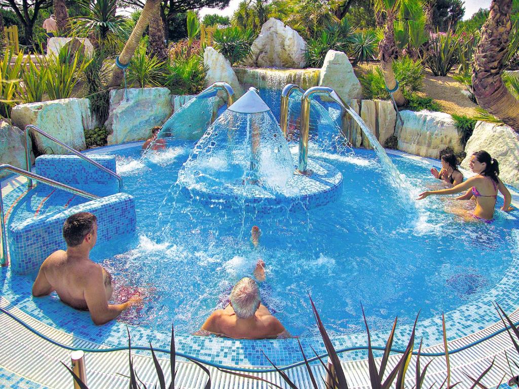 a group of people playing in a swimming pool at Portofelice Camping Village in Eraclea Mare