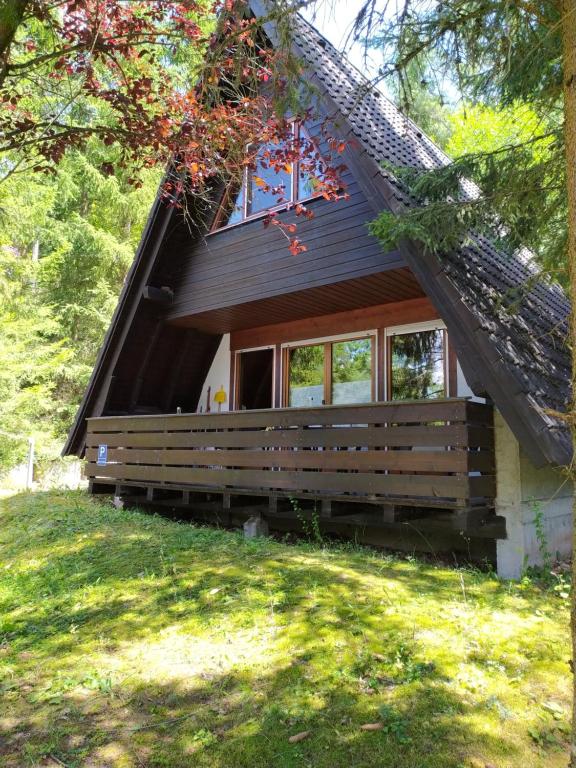 a cabin in the woods with a porch and windows at Ferienhaus Eugenie in Sulzfeld (im Grabfeld)