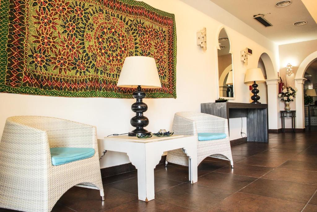 a room with two chairs and a table with a lamp at Hotel O'scià in Lampedusa