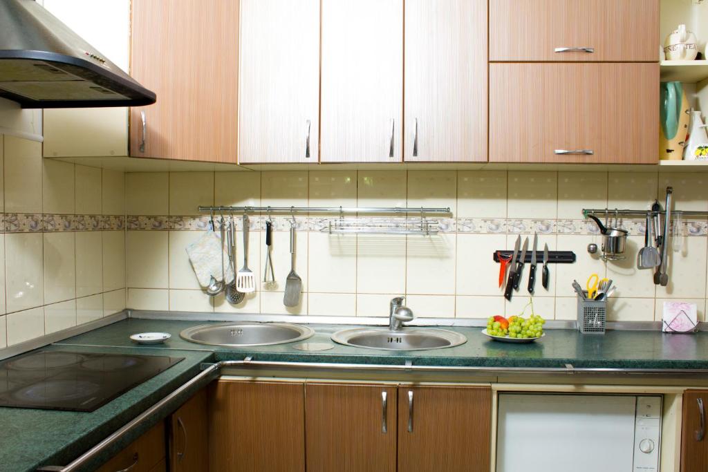 una cocina con 2 lavabos y armarios de madera en КЛУБ B55 en Dnipro