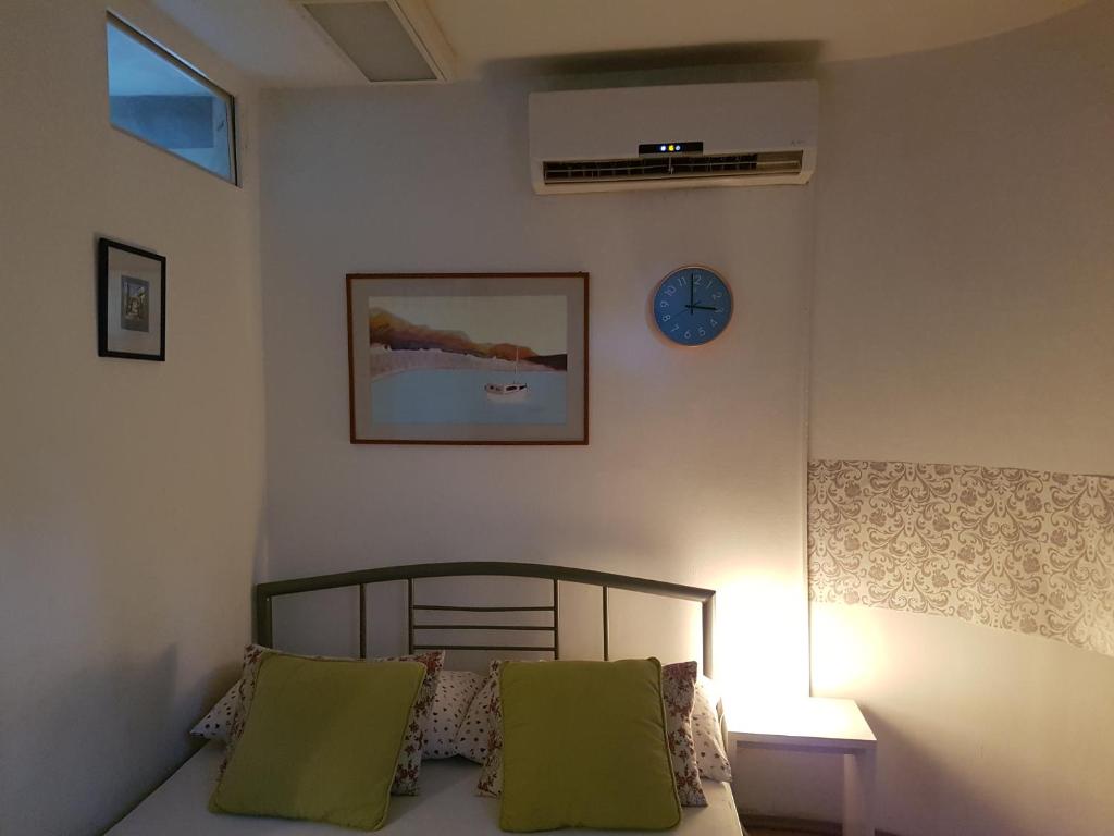 - une chambre avec un lit et une horloge murale dans l'établissement Otto e mezzo, à Split