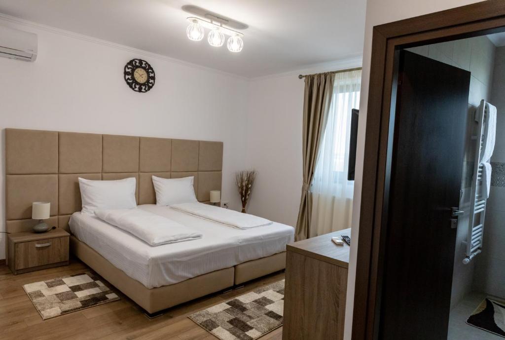 a bedroom with a bed and a clock on the wall at Pensiunea Sofia in Satu Mare
