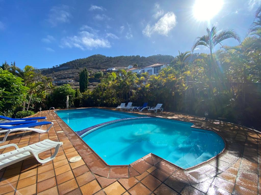 una piscina con patio y sillas alrededor en Villa Colon, en Fuencaliente de la Palma