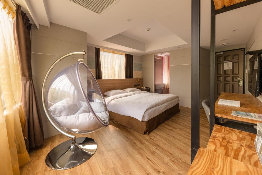 1 dormitorio con cama, silla y escritorio en RF Hotel - Zhongxiao, en Taipéi