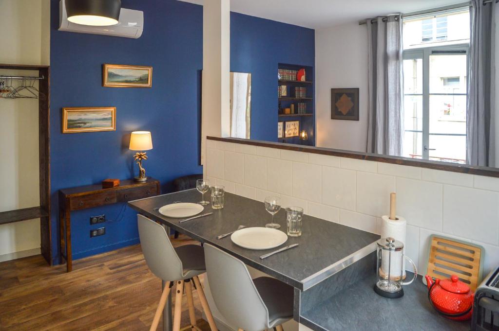 - une salle à manger avec une table, des chaises et un miroir dans l'établissement Les Appartements du Palais, à Bergerac