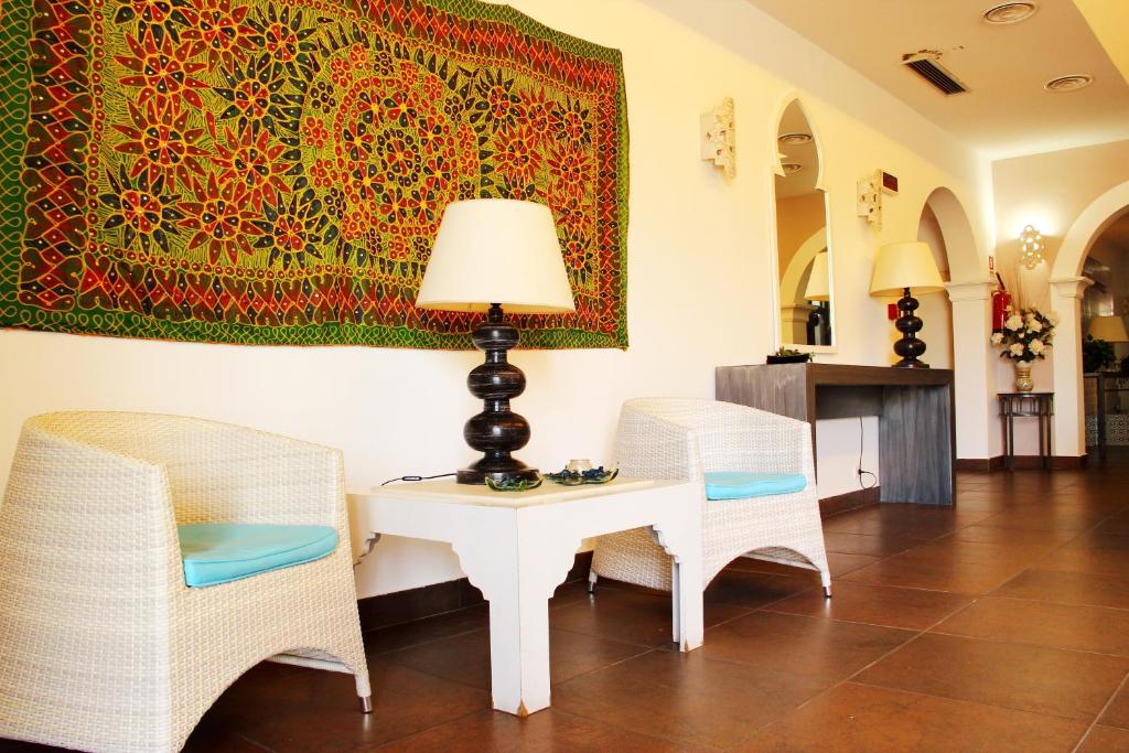 a room with a table and two chairs and a rug at Hotel O'scià in Lampedusa