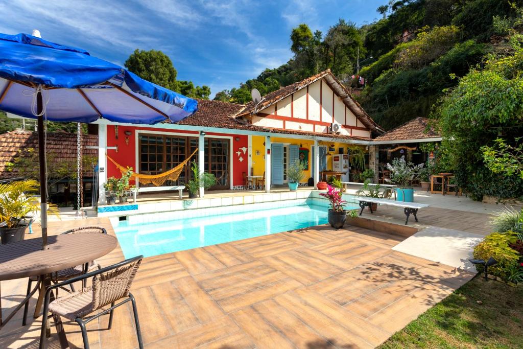 uma casa com uma piscina e um pátio em B & B Gourmet Itaipava em Itaipava