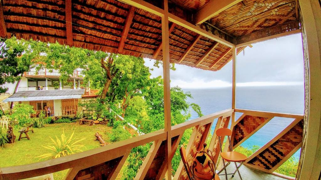 a balcony of a house with a view of the ocean at Stay N Save B&B in Oslob