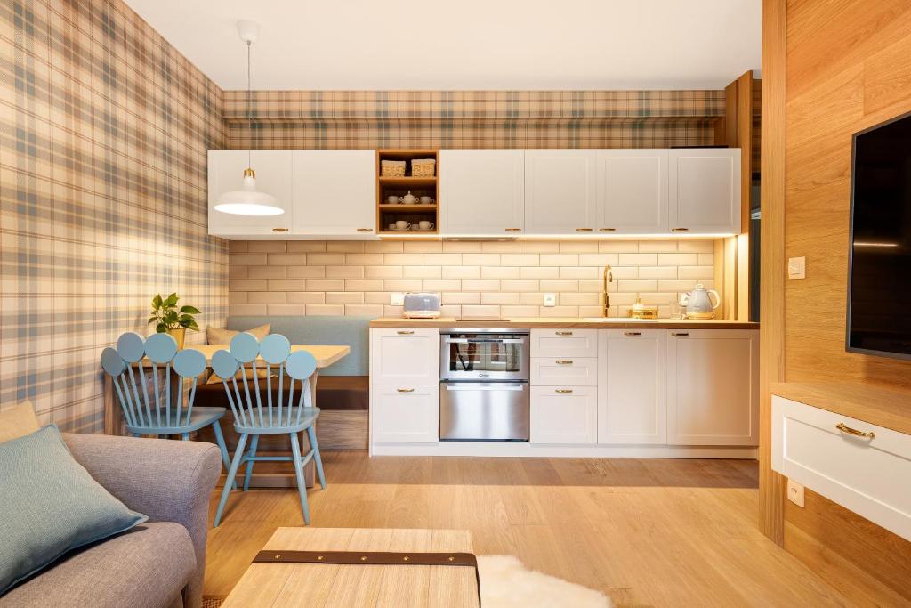 cocina y sala de estar con sofá y mesa en VRÁTNA Apartmány Stoh B1 en Terchová