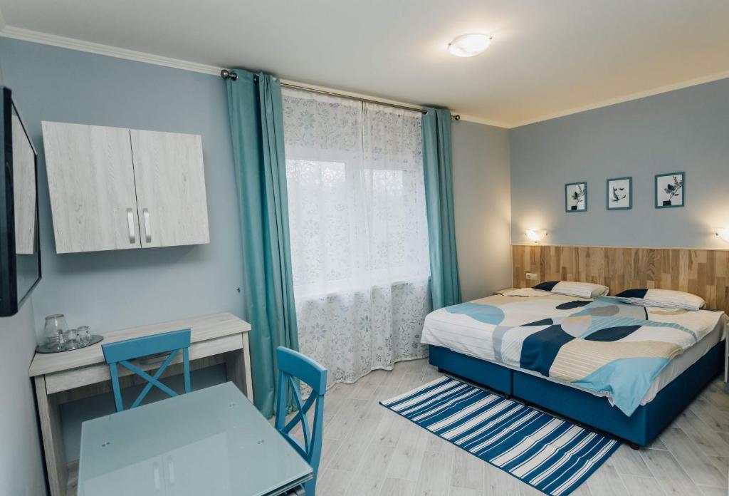 sypialnia z łóżkiem, biurkiem i oknem w obiekcie Villa Grey House w mieście Berehowo