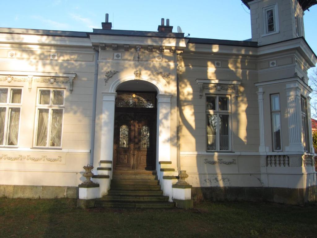 a white house with stairs leading to a door at Apartmán U Borovice in Rychnov nad Kněžnou