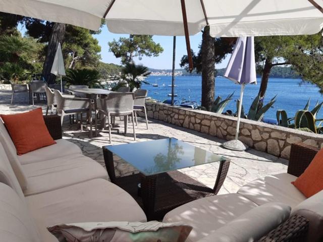 a patio with white couches and a table and chairs at Apartments & Rooms Bianca in Mali Lošinj