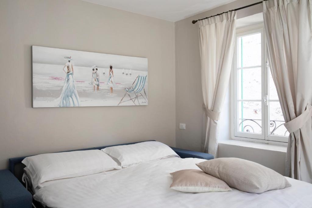 Schlafzimmer mit einem Bett und einem Fenster mit einem Bild in der Unterkunft Borgo Antico in Luino