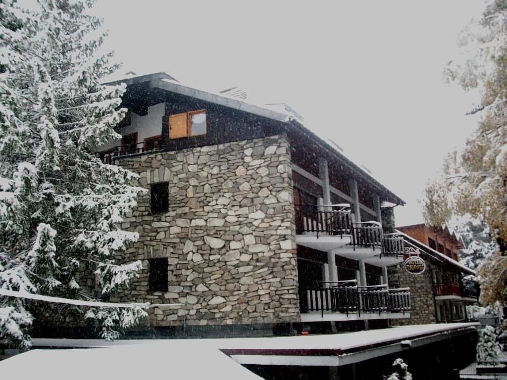 a large stone building with snow on the ground at Hotel Tripoli La Margherita in Limone Piemonte