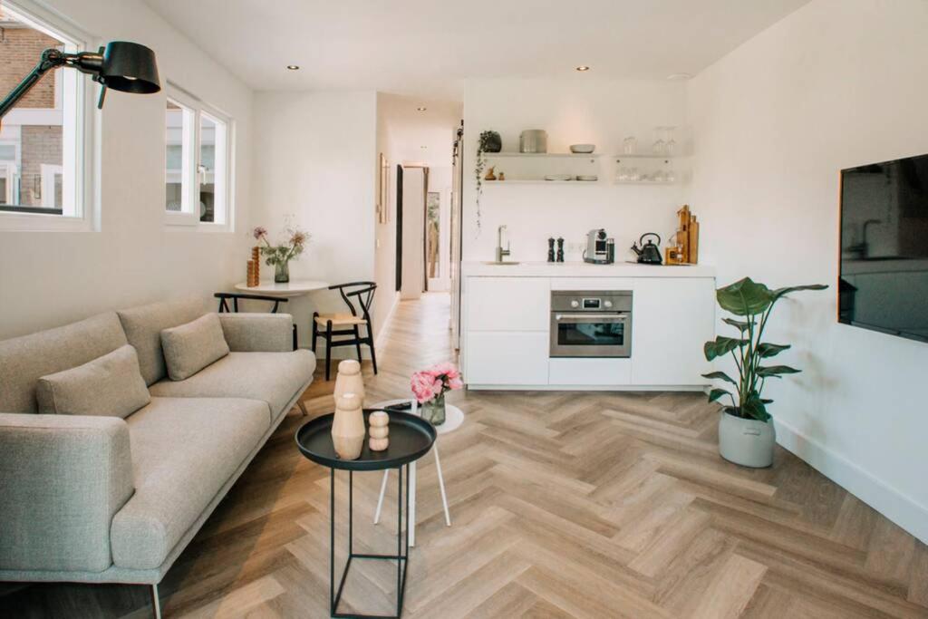 a living room with a couch and a table at The Pine Tree House in Zandvoort