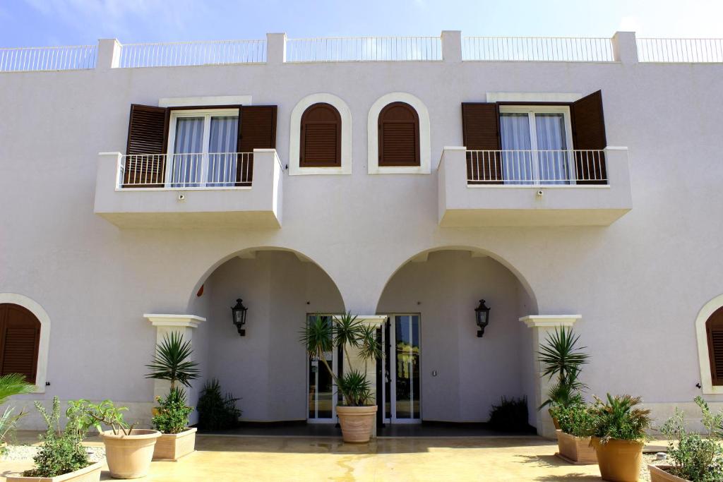 un gran edificio blanco con arcos y ventanas en Hotel O'scià en Lampedusa