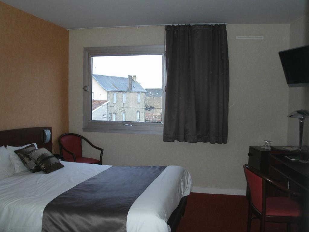 a hotel room with a bed and a window at Cit&#39;Hotel Saint Jacques in Parthenay
