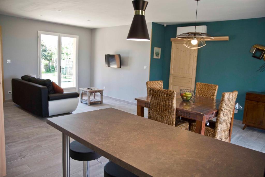 a living room with a table and chairs and a couch at Gîte Les Bourdettes in Auvillar