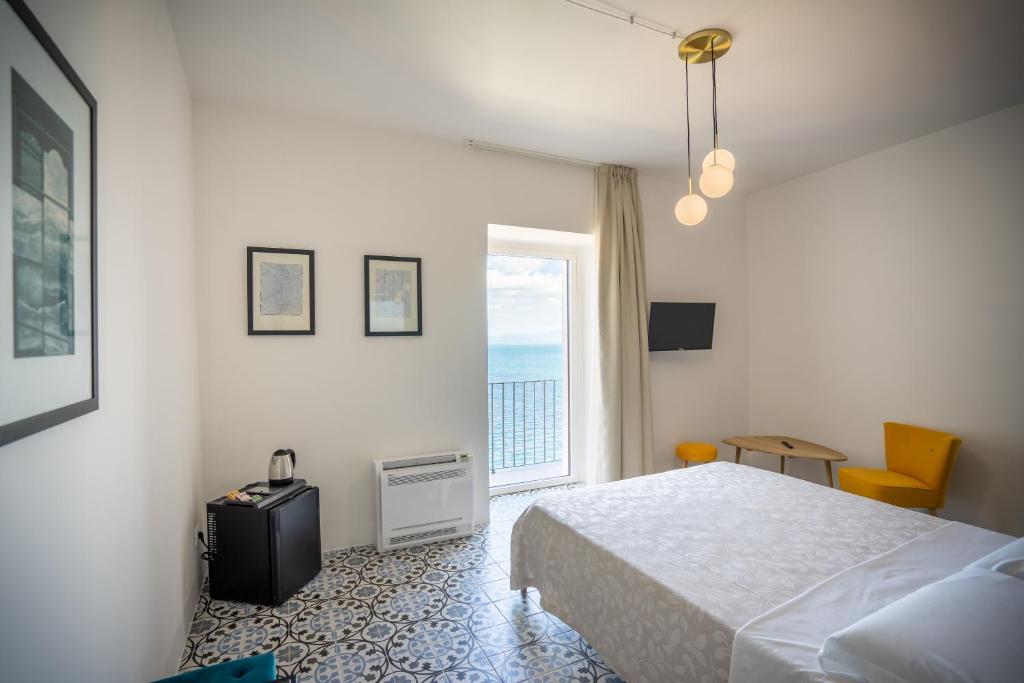 sypialnia z łóżkiem i dużym oknem w obiekcie Borgo dei Saraceni - Flower Home w Agropoli