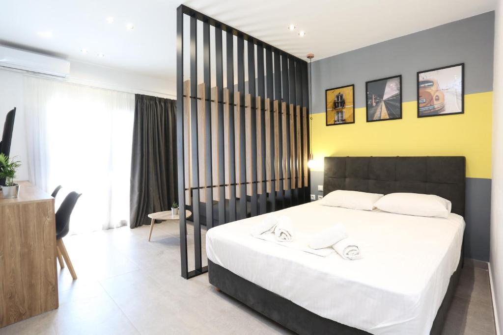 1 dormitorio con 1 cama grande y pared amarilla en Downtown Seaside Suites en Tesalónica
