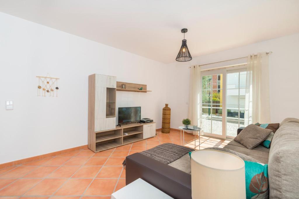 a living room with a couch and a tv at Formosa Bay by Algartur in Cabanas de Tavira