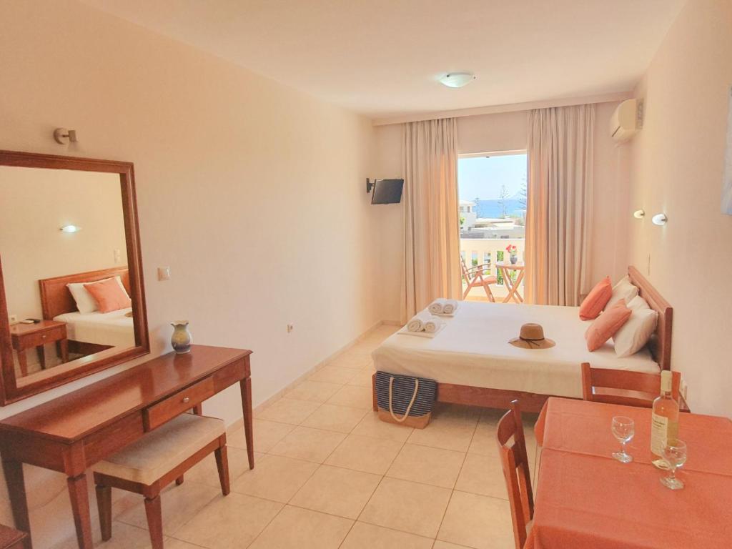 - une chambre d'hôtel avec un lit et un miroir dans l'établissement Kalimera Hotel, à Agia Marina