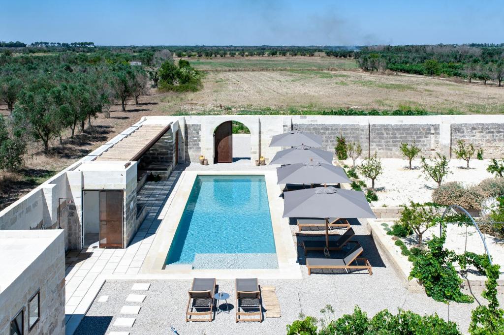 an overhead view of a swimming pool with umbrellas and chairs at Masseria Pezza in Salice Salentino