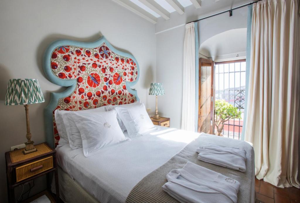 a bedroom with a large bed with a red headboard at Posada La Sacristía Tarifa in Tarifa